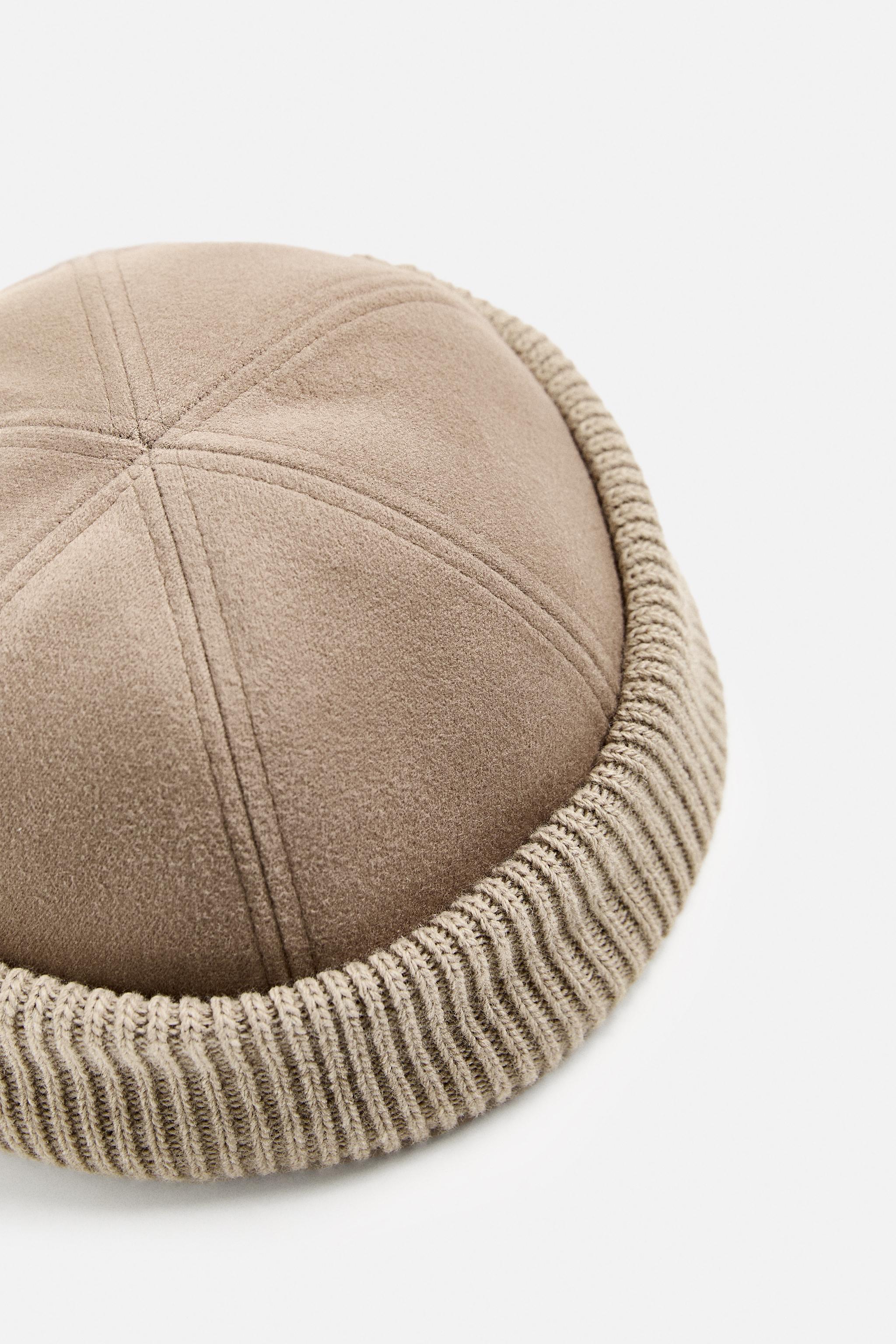 Hat made of tonal matching fabrics with turned-up knit brim. Adjusts with loop. Product Image