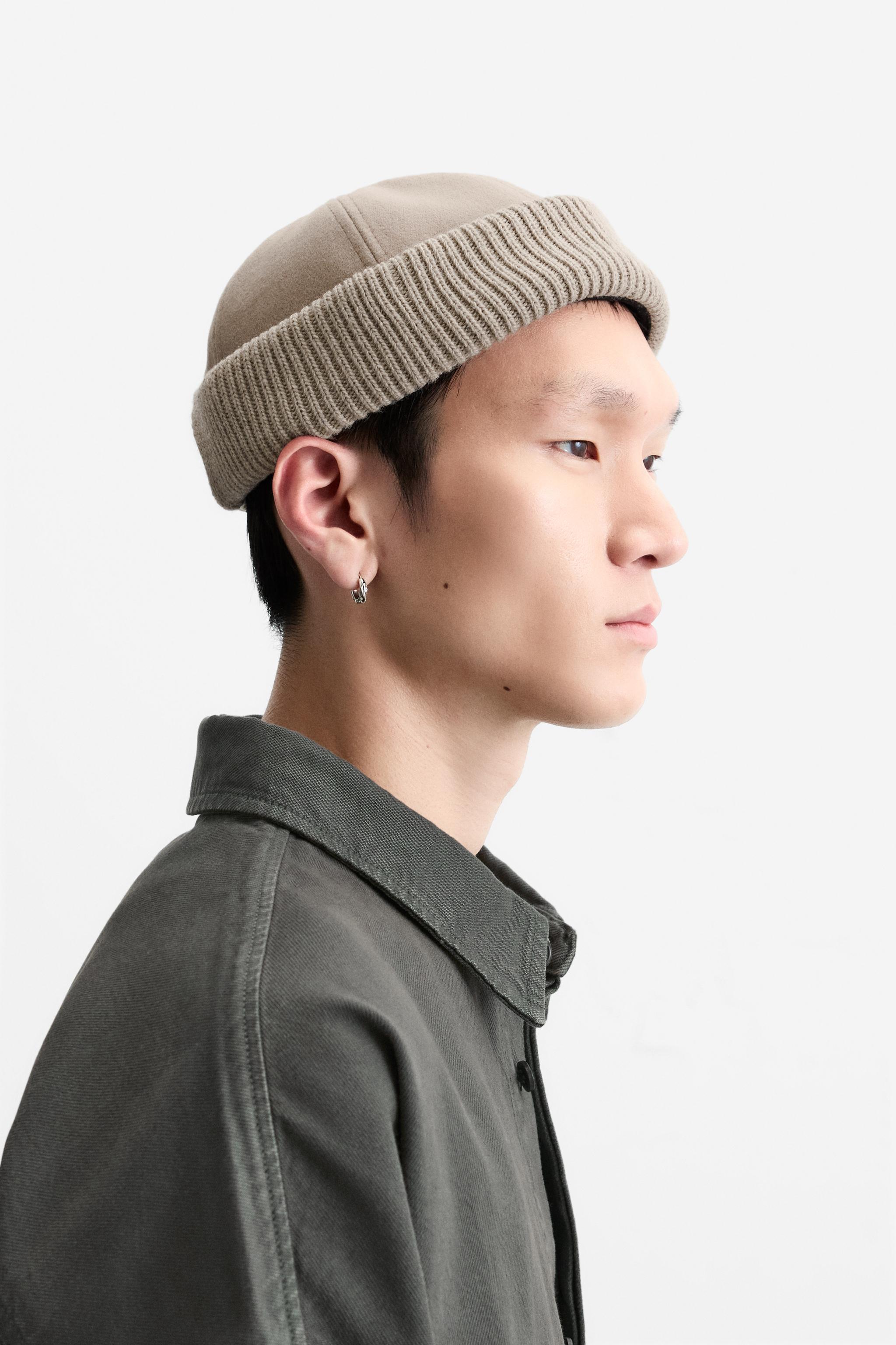 Hat made of tonal matching fabrics with turned-up knit brim. Adjusts with loop. Product Image