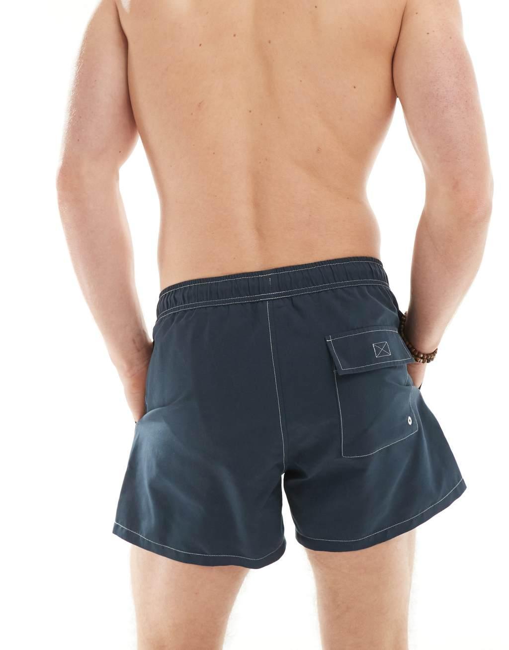 ASOS DESIGN swim shorts in short length with contrast stitch detail in navy Product Image