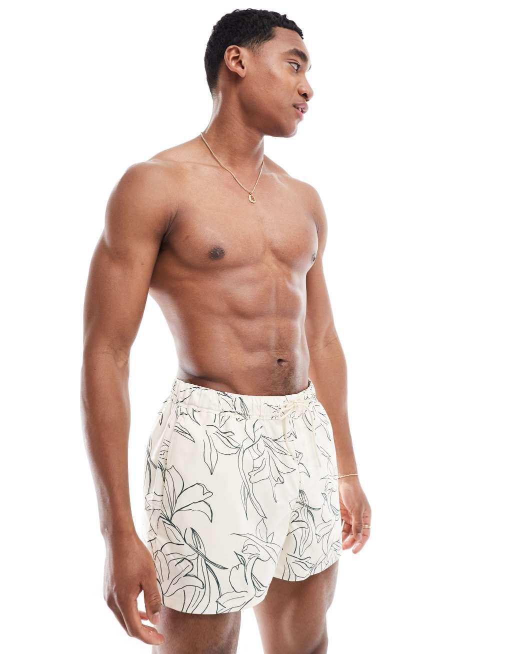 ASOS DESIGN swim shorts in short length with floral print in beige Product Image