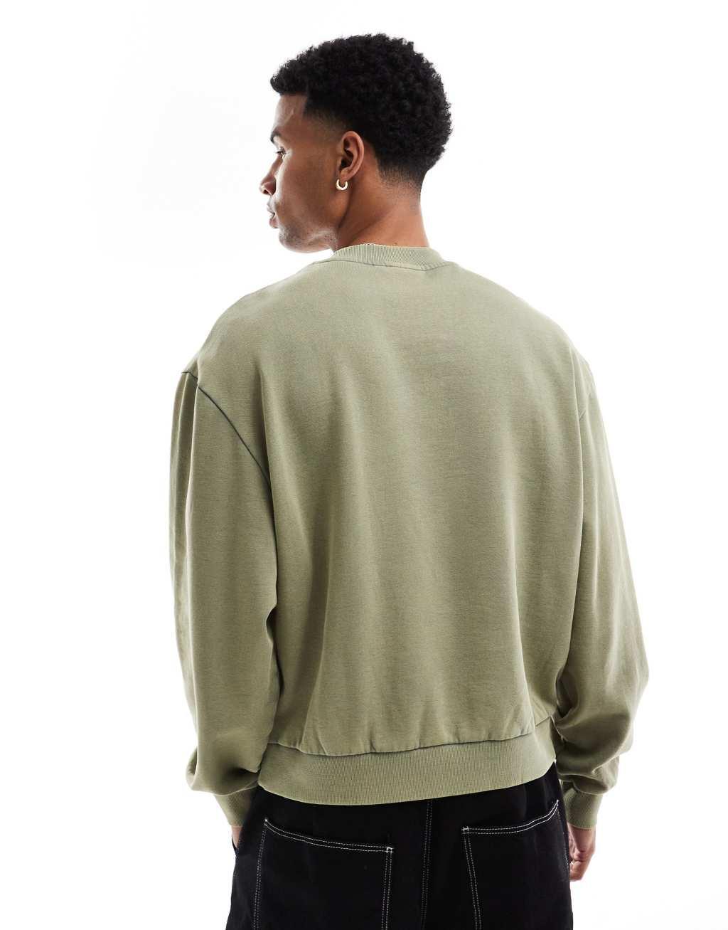 ASOS DESIGN boxy oversized sweatshirt with acid wash and layered print in green Product Image