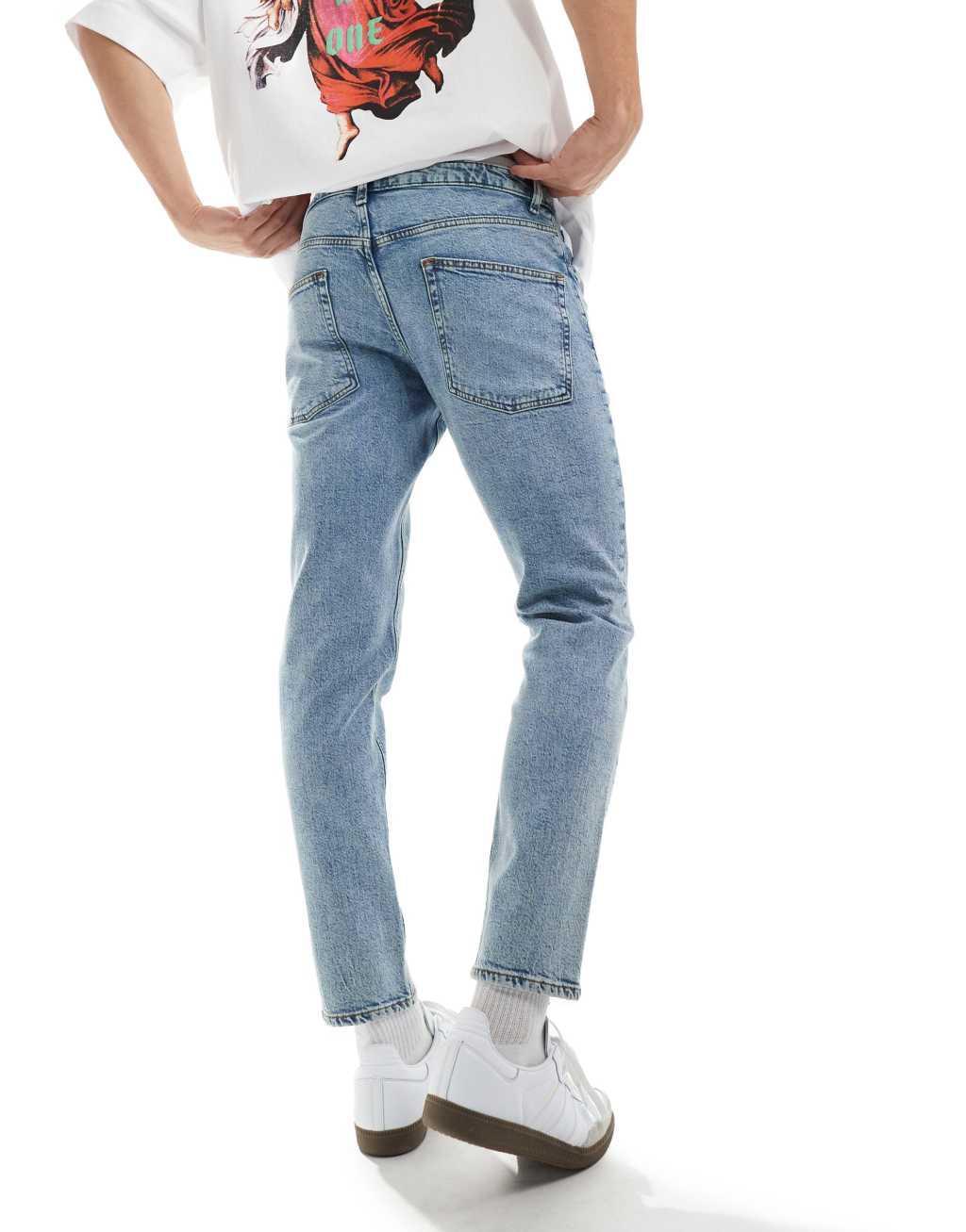 ASOS DESIGN stretch tapered jeans in light wash blue Product Image