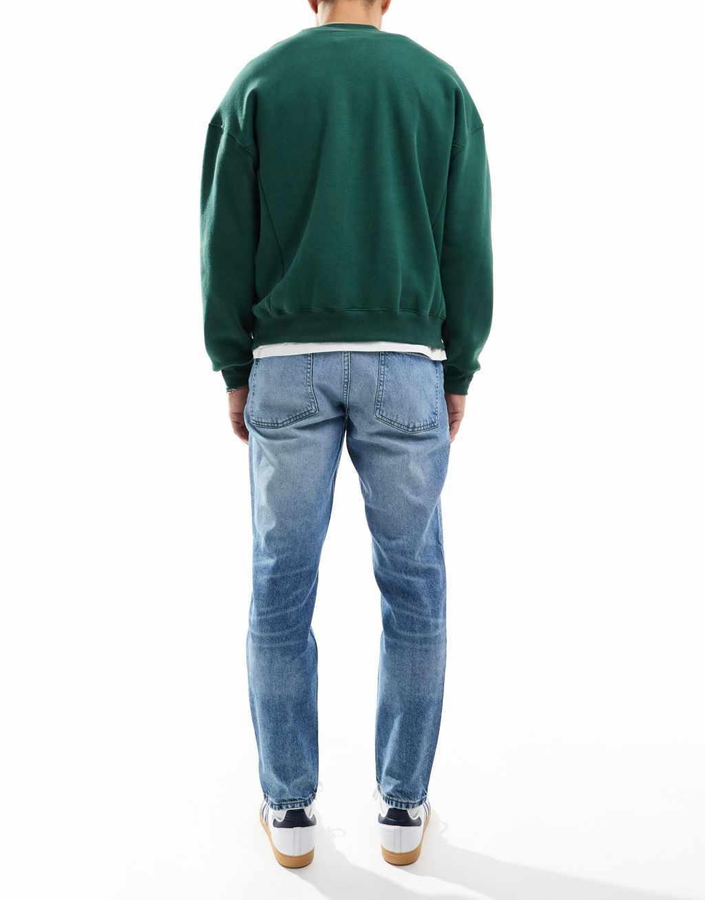 ASOS DESIGN tapered jeans in mid wash blue Product Image