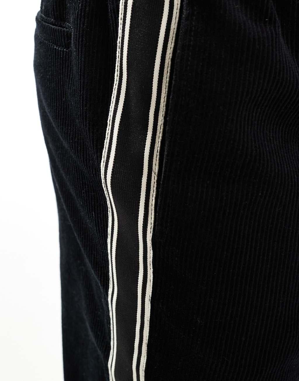 ASOS DESIGN relaxed corduroy pants with side taping in black Product Image