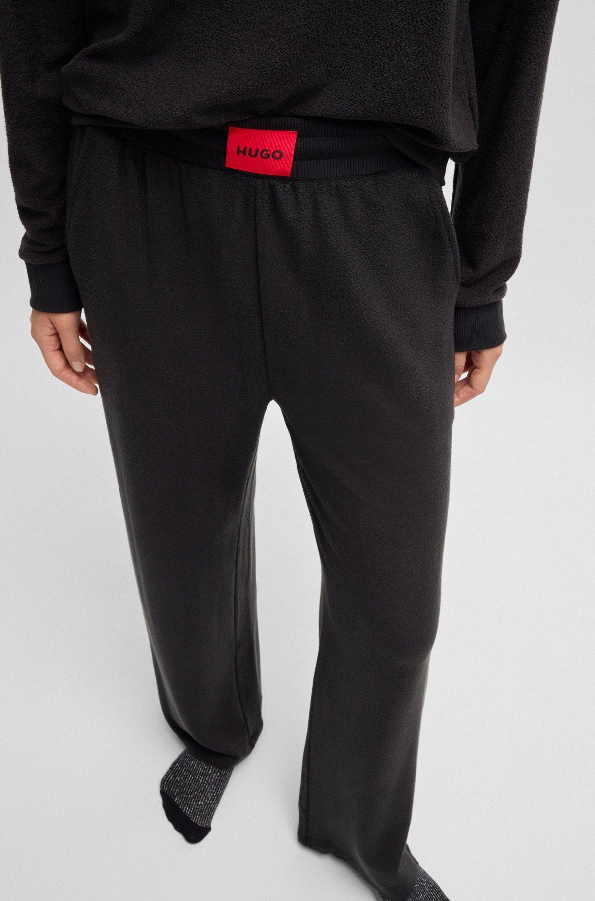 Terry tracksuit bottoms with red logo label Product Image