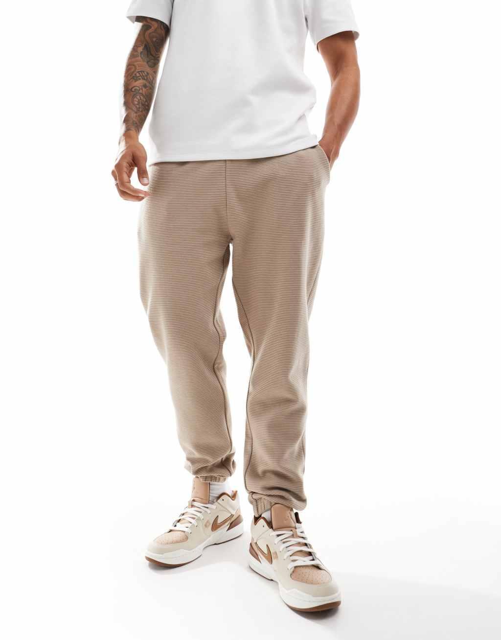 ASOS DESIGN tapered ribbed sweatpants in beige Product Image