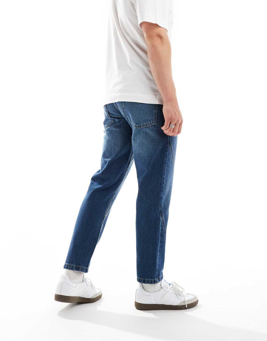 ASOS DESIGN tapered fit jeans with paneling detail in mid wash blue  Product Image