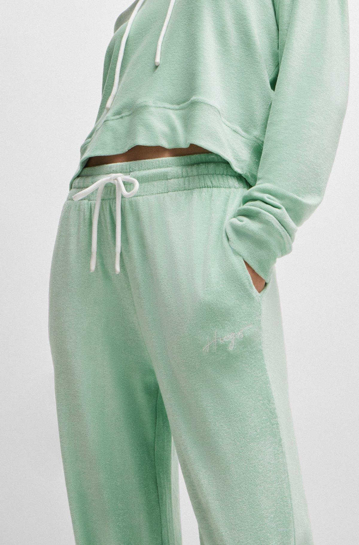 Cuffed tracksuit bottoms in terry fabric with handwritten logo Product Image