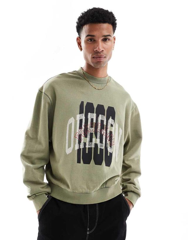 ASOS DESIGN boxy oversized sweatshirt with acid wash and layered print in green Product Image