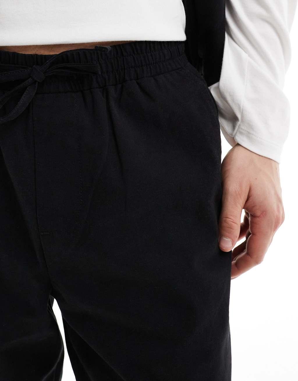 ASOS DESIGN tapered pull on pants with back pocket patch in black Product Image