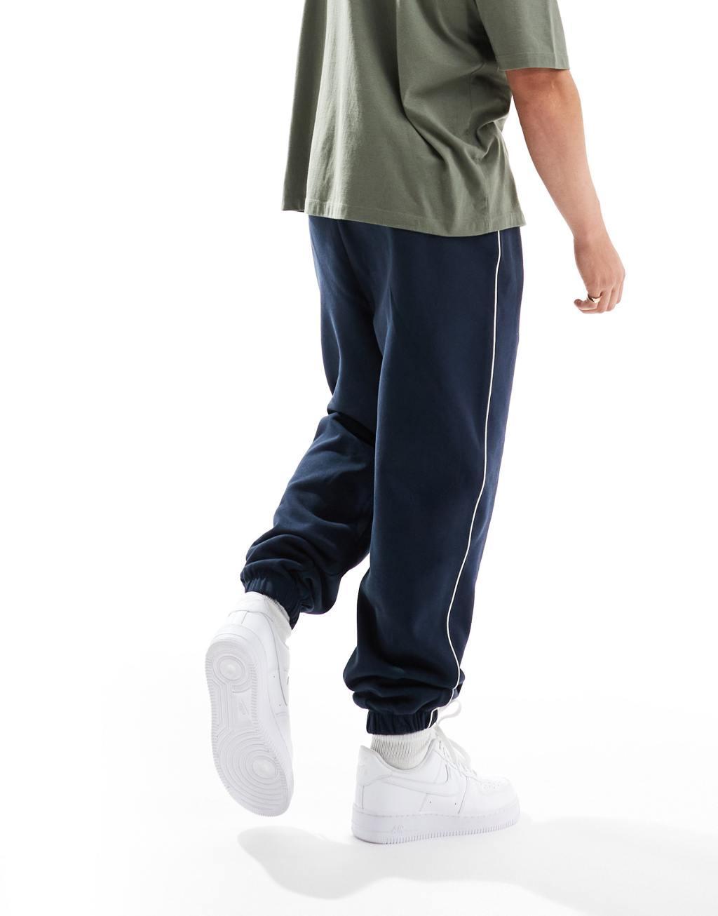 ASOS DESIGN oversized sweatpants with piping in navy Product Image