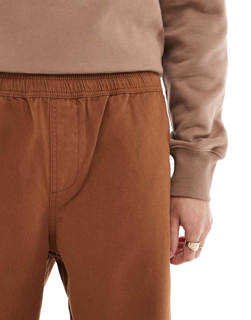 ASOS DESIGN baggy pull on pants with back pocket patch in brown Product Image