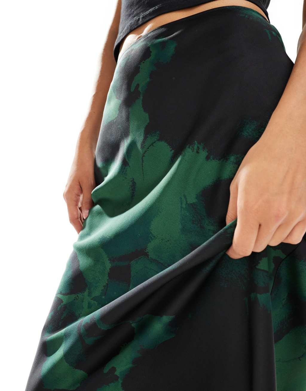 ASOS DESIGN satin bias cut midi skirt in green & black blurred floral Product Image