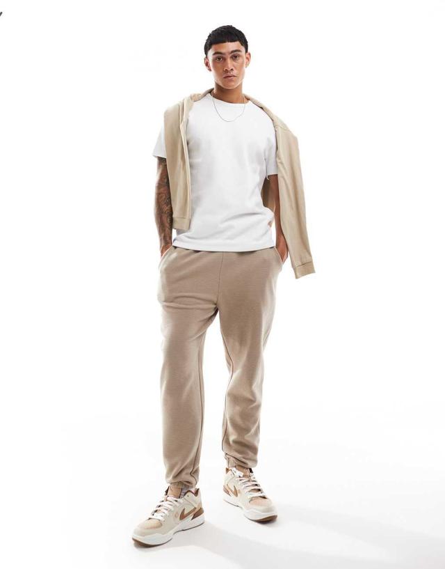 ASOS DESIGN tapered ribbed sweatpants in beige Product Image