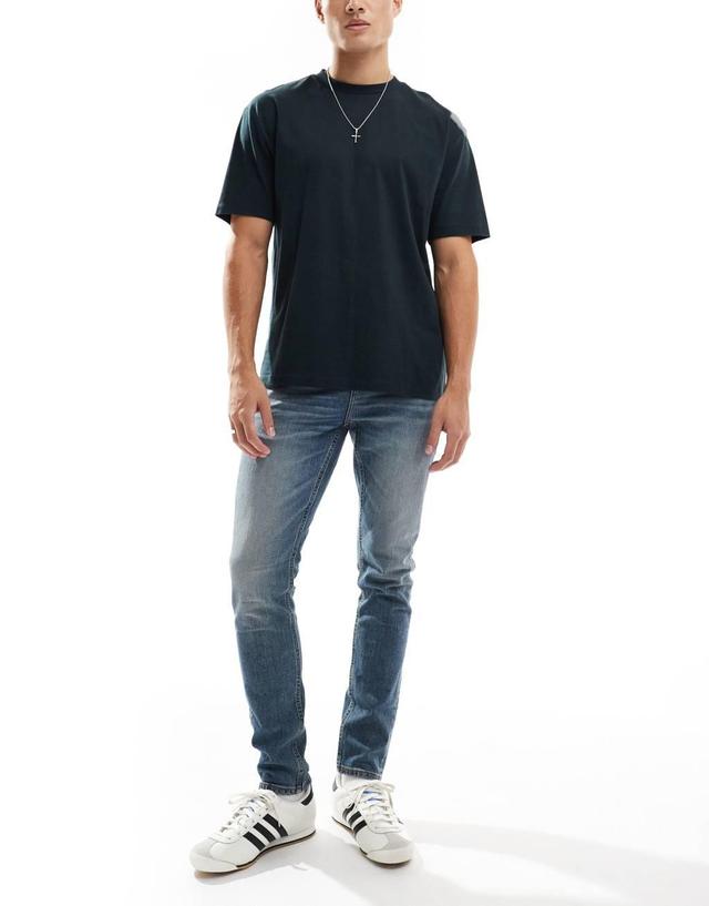 ASOS DESIGN skinny jeans in mid wash blue Product Image