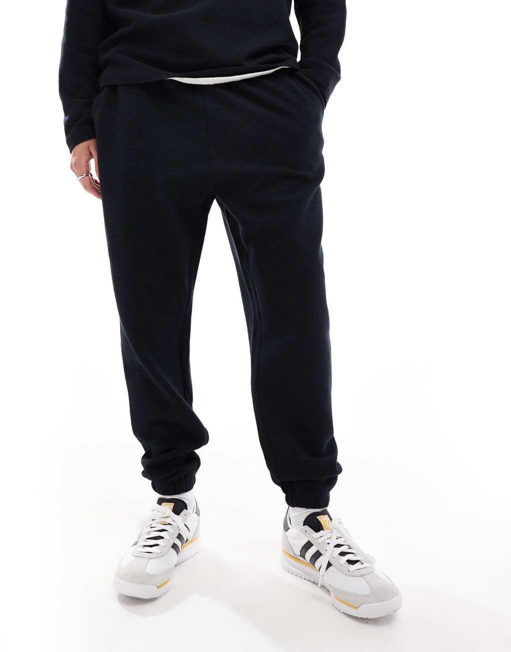 ASOS DESIGN tapered rib sweatpants in black Product Image